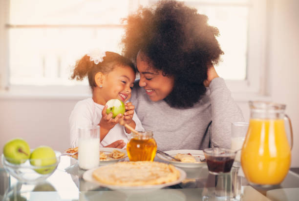 istock African-American young mother and daughter having breakfast 1144667489