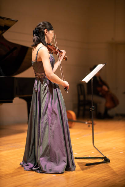istock One woman playing violin at concert hall 1144671091