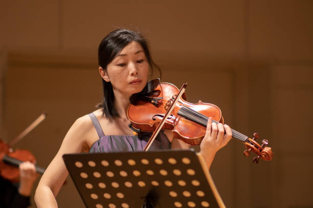 istock Woman playing violin at concert hall 1144671104