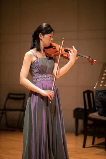 istock One woman playing violin at concert hall 1144671129