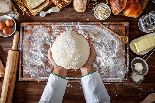 Panadería artesanal: manos del chef artesano amasando masa photo