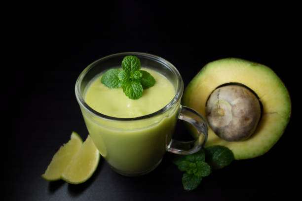 Avocado smoothie withi mint and lime on dark background with copy space for text. Selective focus. Healthy food concept.