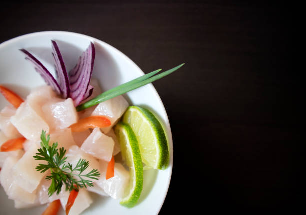 Traditional Ceviche bowl with white fish. Top view on dark background with copy space.