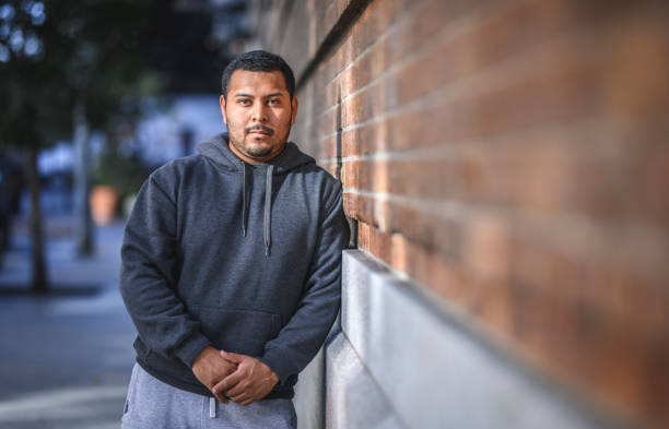 istock Man leaning on brick wall in the city and looking at camera 1144679419