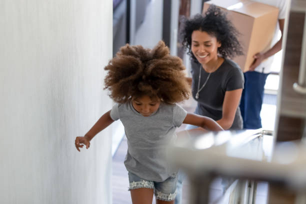 familia africana explorar su nuevo hogar de ir al segundo piso - moving house physical activity moving van box fotografías e imágenes de stock