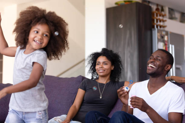 istock Family having fun with kid and soap bubbles at home 1144680170