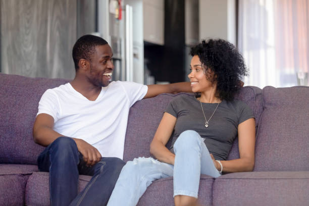 istock Couple sitting on couch talking spending time together at home 1144680173