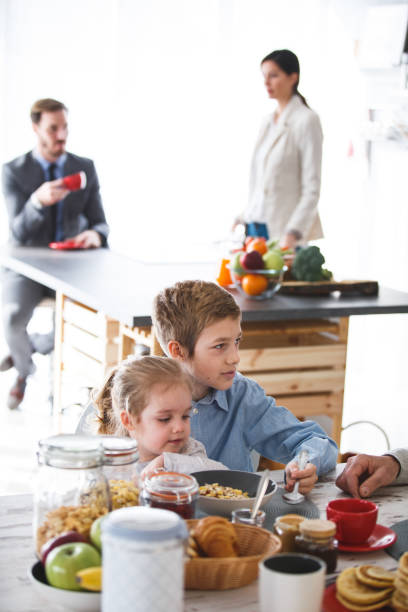 istock Children having breakfast, parents drinking morning coffee in the kitchen 1144680229