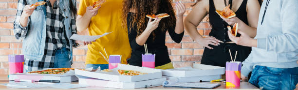 бизнес-команда обед пицца образ жизни миллениалов - women dependency business time стоковые фото и из�ображения