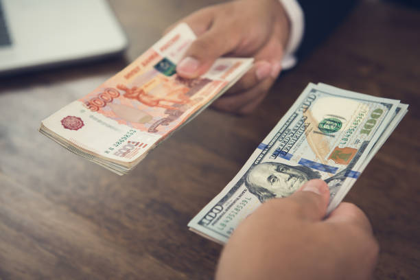 istock Hand holding US dollar bills trading with Russian ruble currency 1144699193