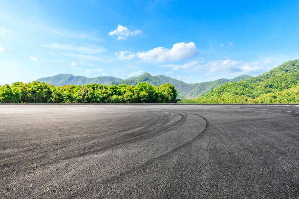 Empty asphalt race track and green mountains natural landscape Asphalt race track ground and green mountains natural landscape motor racing track photos stock pictures, royalty-free photos & images