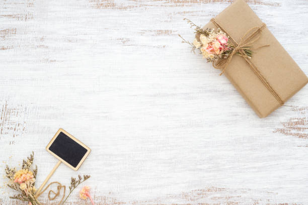 istock Beautiful small handmade DIY gift box (package) with flowers and decorative rope on rusty white background. Vintage Retro Style. Flat lay Top view with copy space for your advertisement text. 1144708411