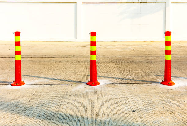 Old white metal bollard with a road behind.