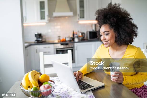 Afro Frau Mit Laptop Zu Hause Und Kaffee Trinken Stockfoto und mehr Bilder von Forschung - Forschung, Internet, Küche