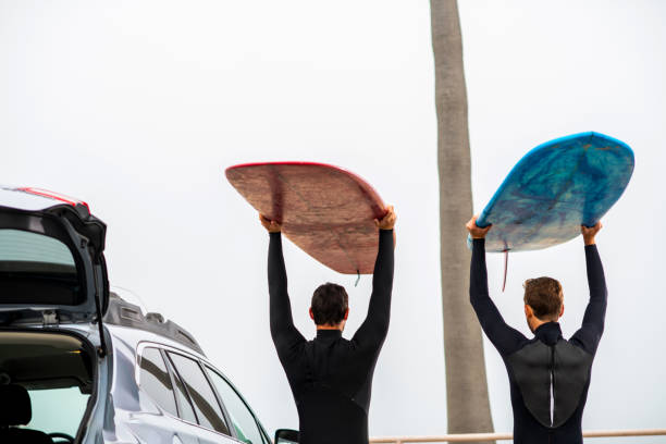 istock Surfers Stand Next to Their Car and Check Out the Waves 1144716343