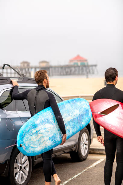 istock Surfers Stand Next to Their Car and Check Out the Waves 1144717822