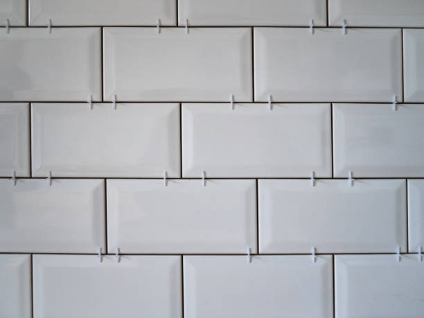 istock Masonry on the wall of white ceramic tiles. Bathroom or kitchen renovation 1144720194