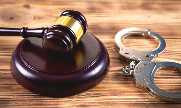 istock gavel and handcuffs on wooden background 1144725217