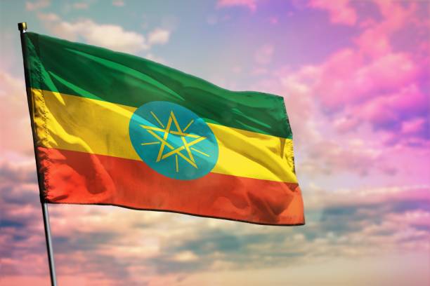 istock Fluttering Ethiopia flag on colorful cloudy sky background. Prosperity concept. 1144726420