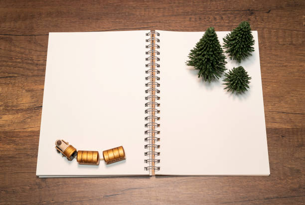 istock Blank white notebook with green pine tree and golden train 1144727806