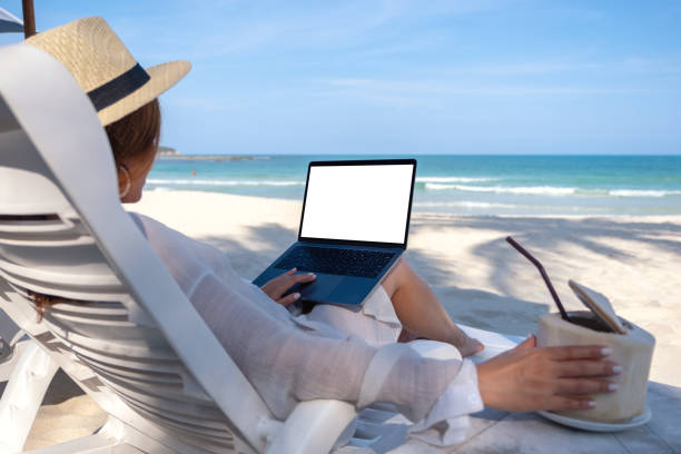 istock a woman holding and using laptop computer with blank desktop screen while laying down on beach chair 1144727816