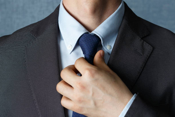 istock Man in suit straightens tie close-up, front view 1144728483