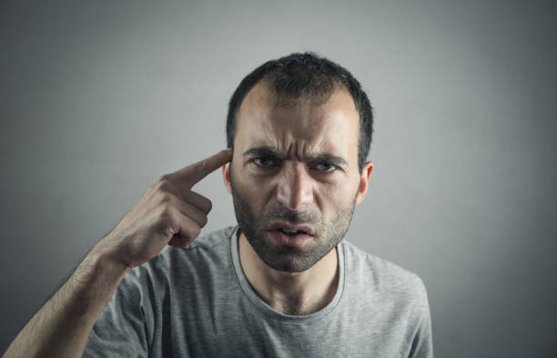 istock Caucasian serious man pointing finger at his temple. 1144730594