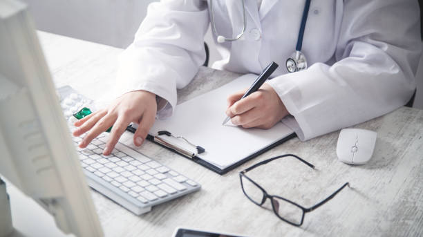 istock Doctor writing in a clipboard at clinic. 1144730693