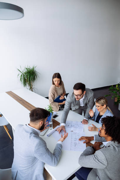 istock Multi ethnic group of architects working on plans in board room 1144730842