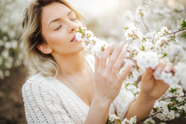 Happy young woman in blooming orchard