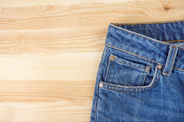 istock Blue jeans on wooden background. 1144733070
