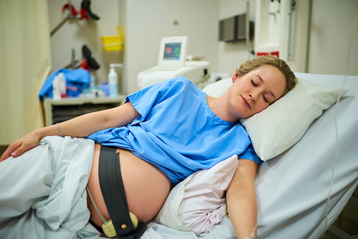 Shot of an attractive young pregnant woman sleeping in her hospital bed