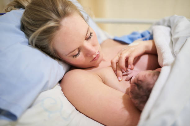 Shot of a beautiful young mother lying in bed with her newly born baby girl in the hospital
