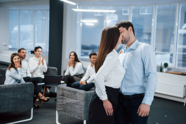 istock Spontaneous lovely kiss between two employees shocked other office workers 1144741314