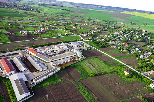 Summer rural landscape, top view. Aerial view of compound plant, fields, animals farms and formal gardens. Industrial zone and farmhouse in village