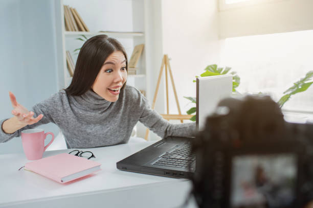 istock Happy and glad girl is looking to the laptop's screen. Se is talking with somebody using internet connection for that. Young lady is smiling. also she is streaming all of that online. 1144746750