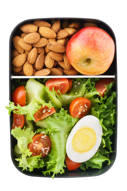 Healthy vegetarian lunch box with salad, nuts and apple. Food delivery concept. Isolated. Top view.