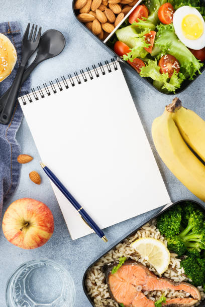 istock Healthy diet lunch boxes with food and empty notepad. 1144751154