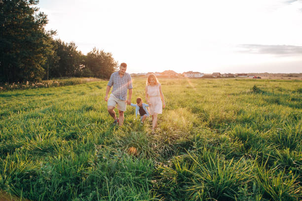 istock Happy boy with parents running in park. Summertime 1144753446