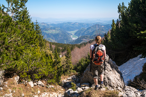 Back view of senior woman standing on the slope of Ratitovec in Julian Alps, and enjoying view, Slovenia