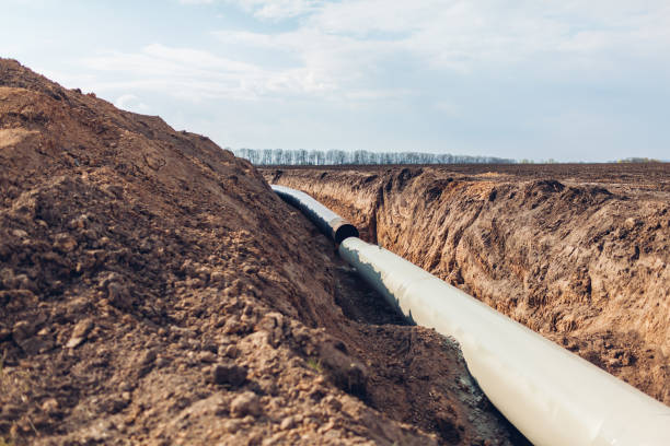 Industrial gas pipeline. Laying new pipes in field underground Industrial gas pipeline. Laying new pipes in field underground. Outdoor construction underground pipeline stock pictures, royalty-free photos & images