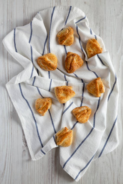 istock Home-baked cottage cheese biscuits on cloth over white wooden surface, side view. Close-up. 1144755833