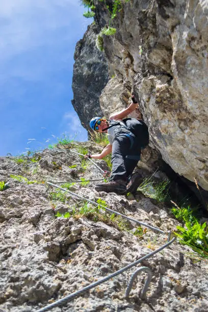 Photo of Lady tourist climbing via ferrata 