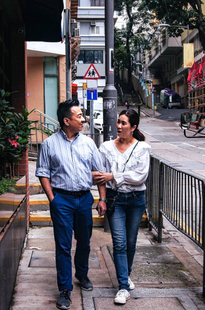 Asian couple looking at each other while walking on Hong Kong's street