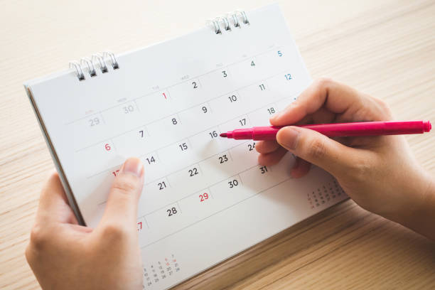 istock Hand with pen writing on calendar page closeup 1144758252