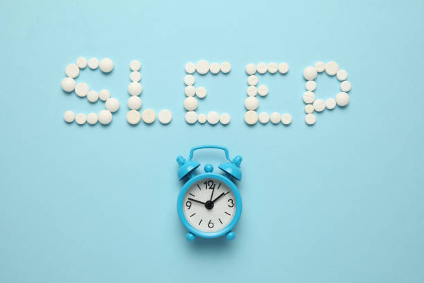 istock Sleeping pills and an alarm clock, insomnia concept. Drugs for treating sleep problems 1144760082