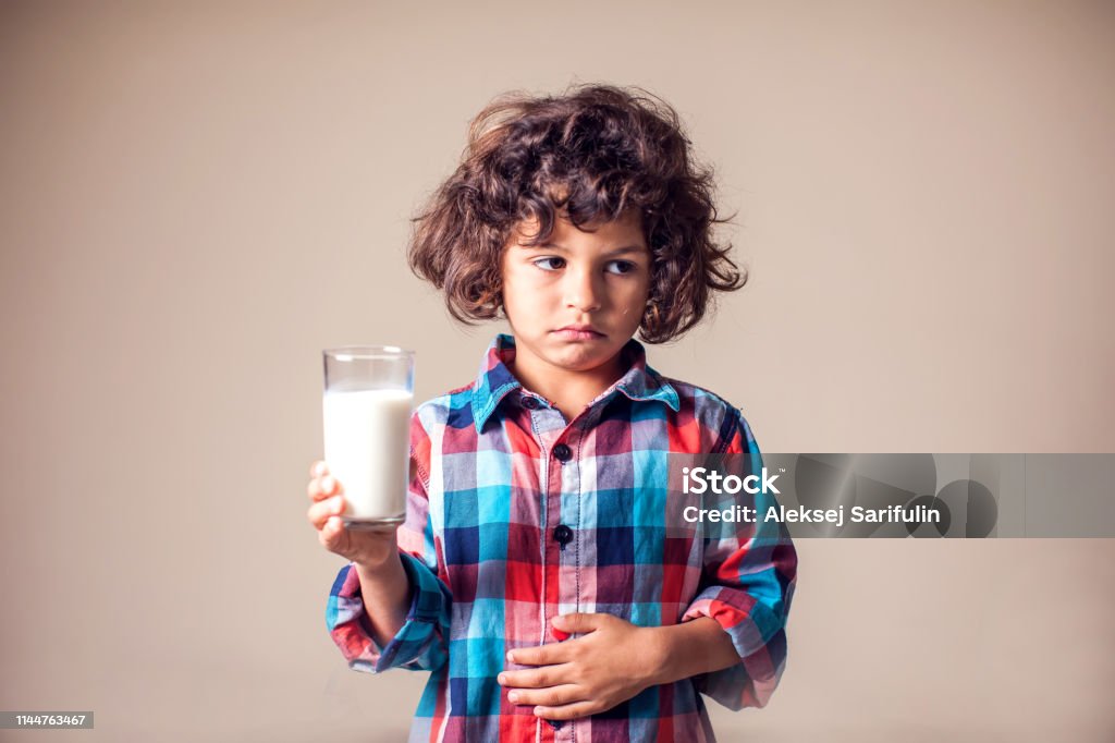 Kind mit Bauchschmerzen hält ein Glas Milch. Milchdärmine Person. Kinder, Gesundheitskonzept. - Lizenzfrei Allergie Stock-Foto