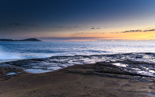 istock Rock Platform Sunrise Seascape with Light Smattering of Clouds 1144764454
