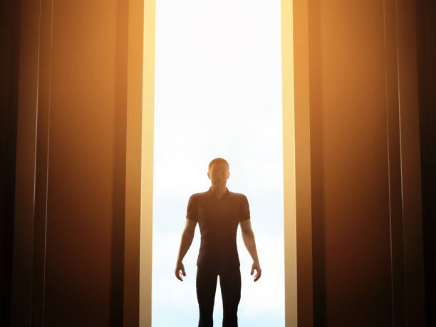 istock Man standing in front of mysterious open door 1144764790