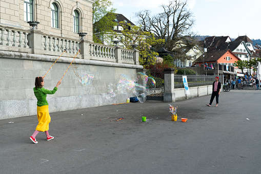 Zug, ZG / Switzerland - 20 April, 2019: street artists making giant soap bubbles during Easter weekend celebrations on Lake Zug